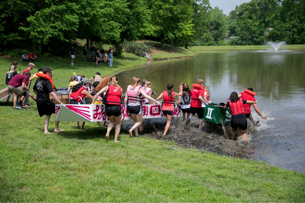 Students carrying boat into water