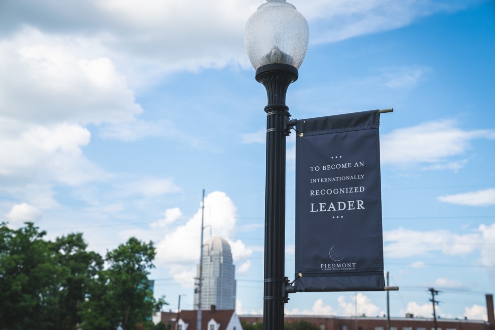 Sign on lamp post reading "to become an internationally recognized leader"