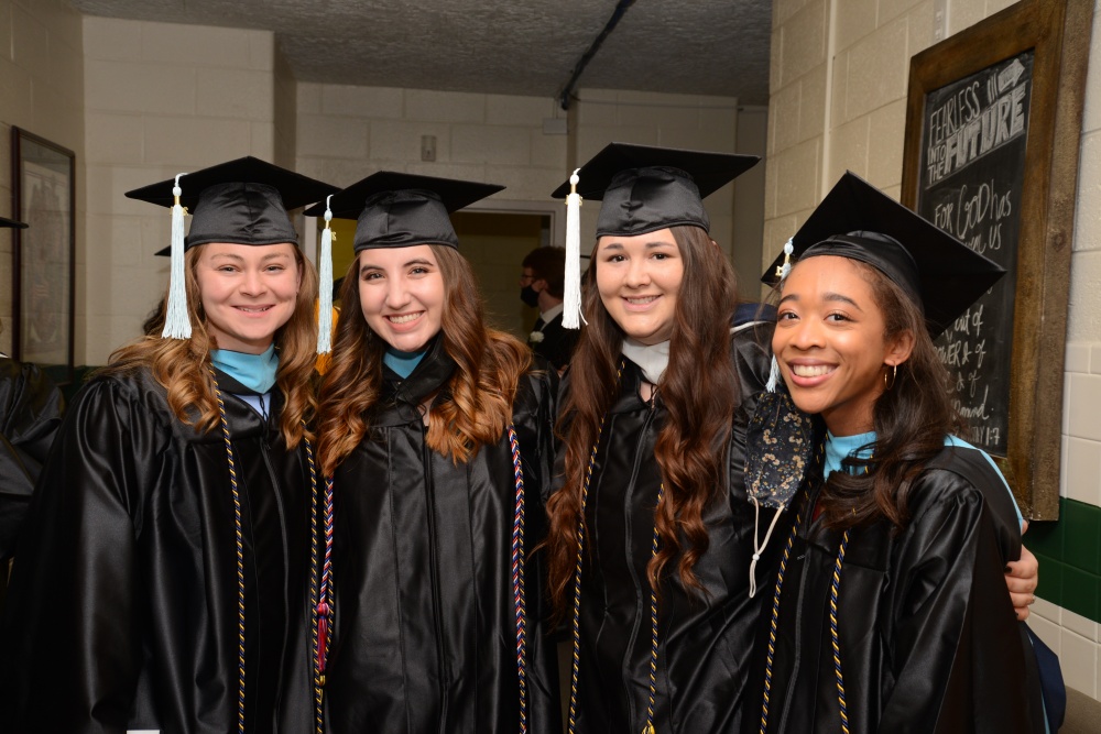 four graduates standing side by side